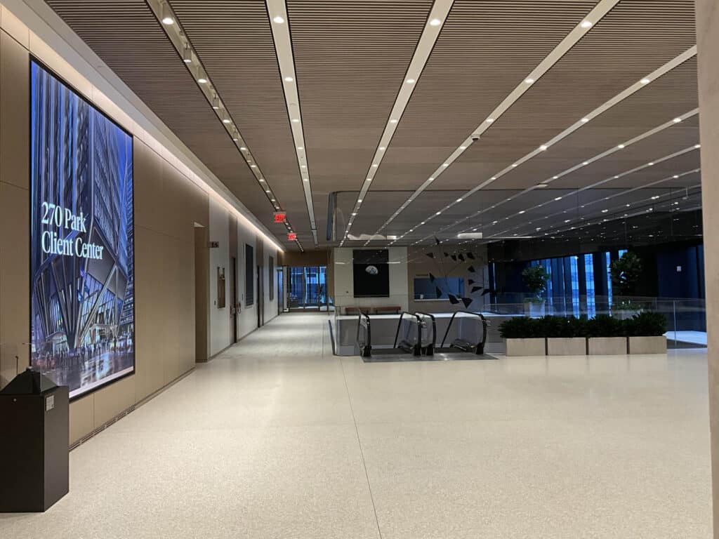 Modern office building lobby with large digital display reading 